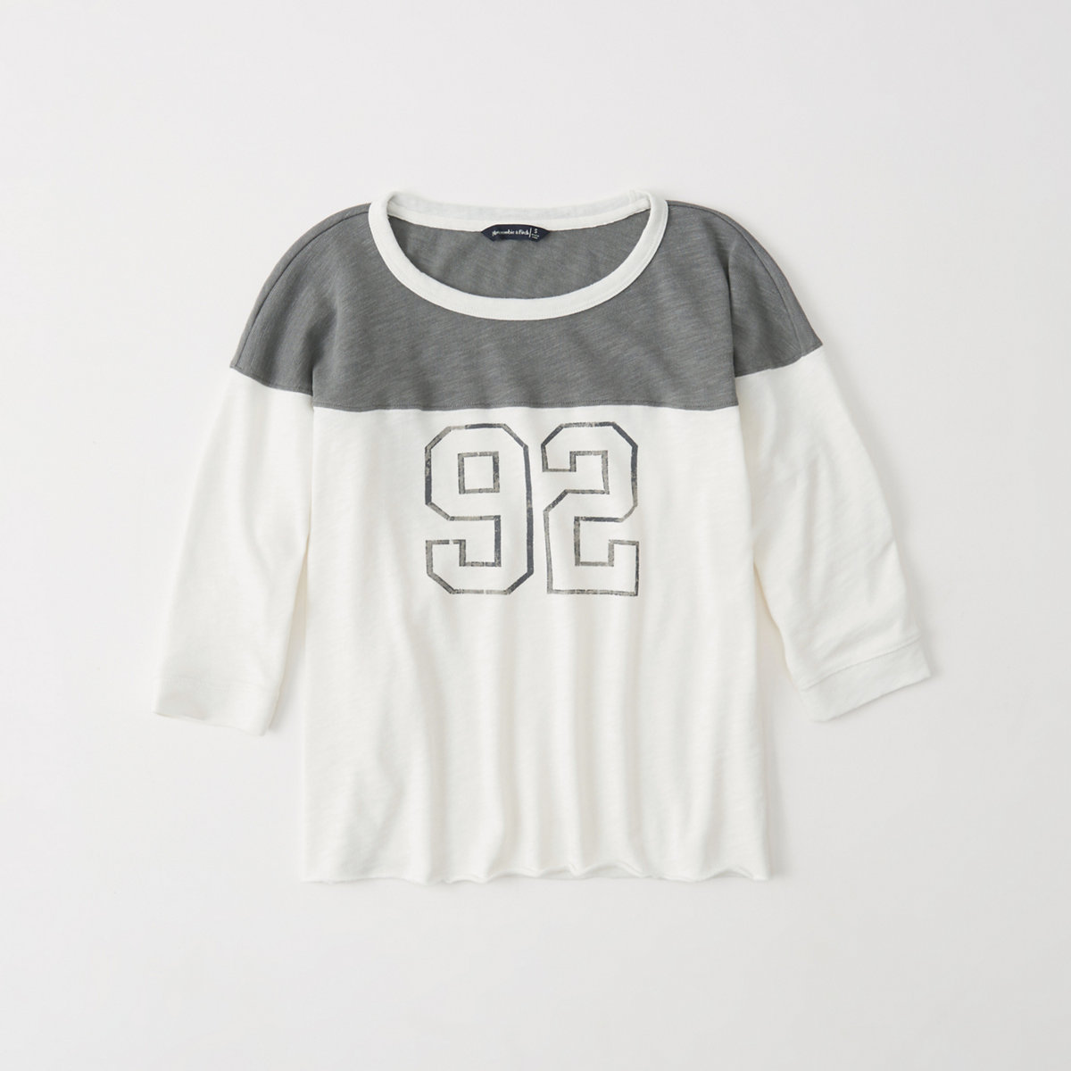 gray and white long sleeved graphic football tee.